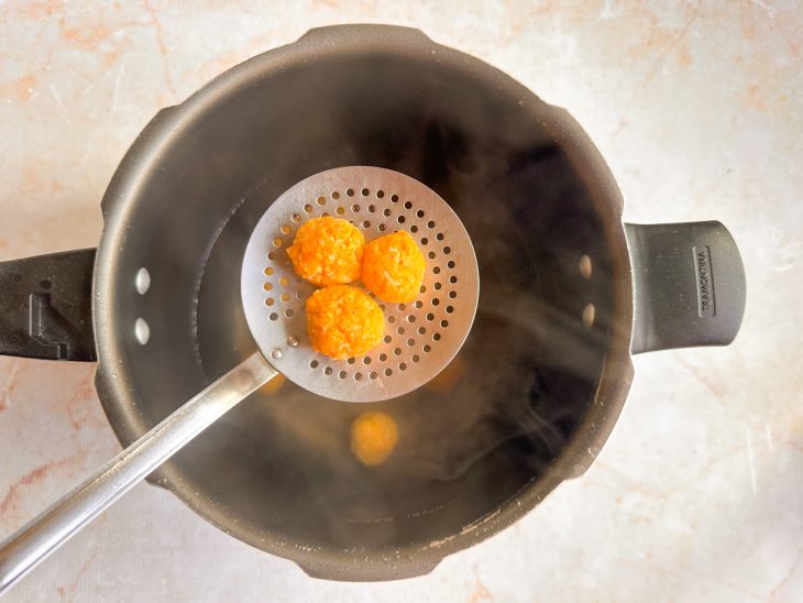 Bolinhas de nhoque numa escumadeira.