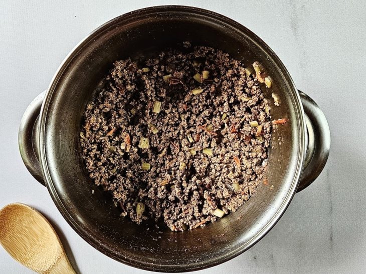 Panela com carne e temperos refogando.
