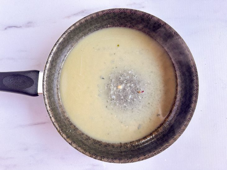 Na frigideira, a água do cozimento com a mistura de manteiga e gorgonzola.