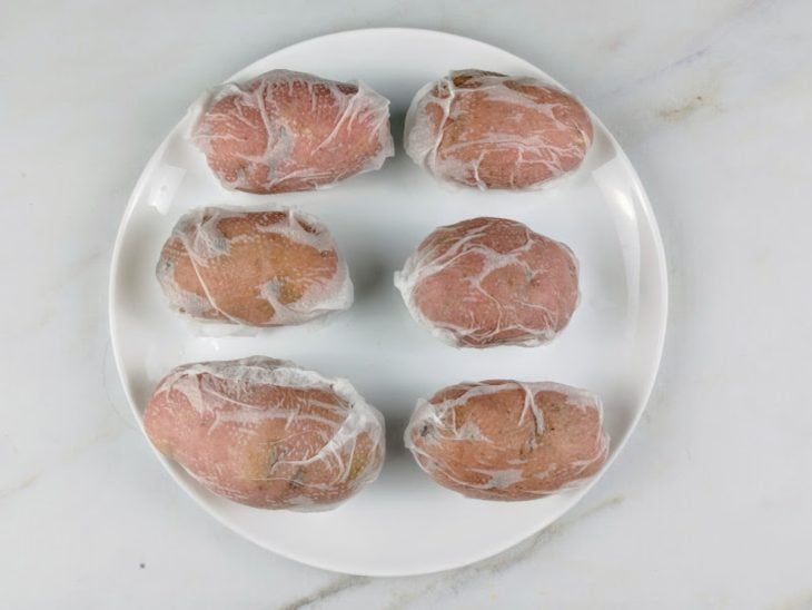 Prato com batatas cozidas e enroladas no papel-toalha.