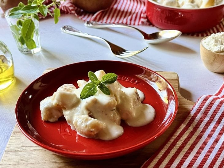 Porção de nhoque de batata em um prato pronto para consumo.