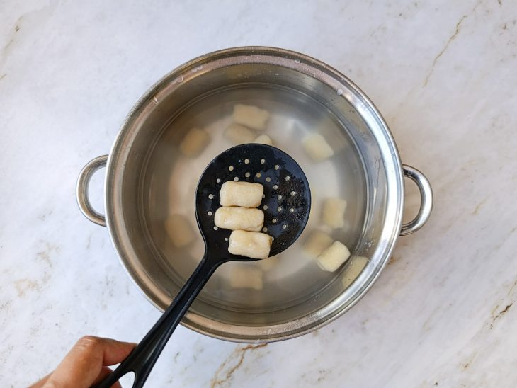 Nhoques cozinhando em água fervente até subir.