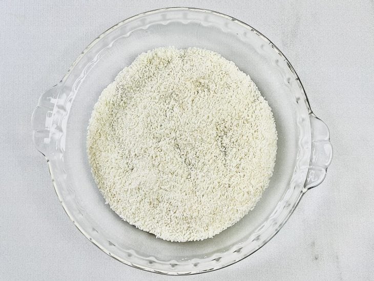 Prato com coco ralado e açúcar misturados.