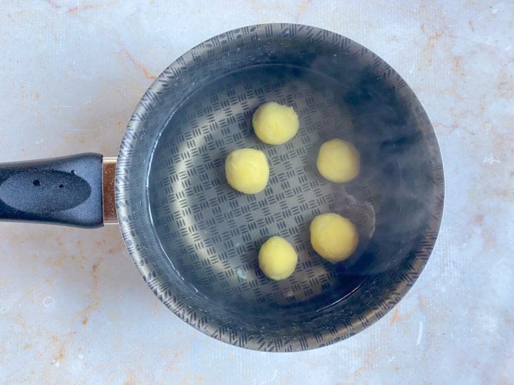 Bolinhas de nhoque cozinhando em uma panela com água e sal.