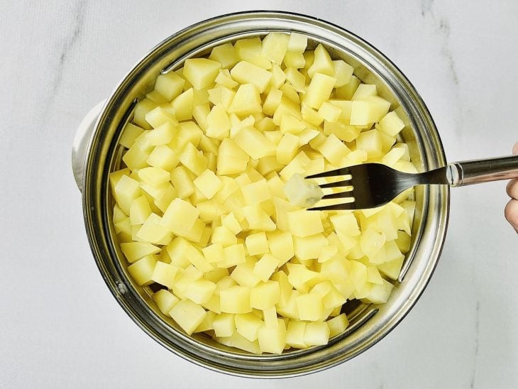 cubinhos de batata cozinhando na panela