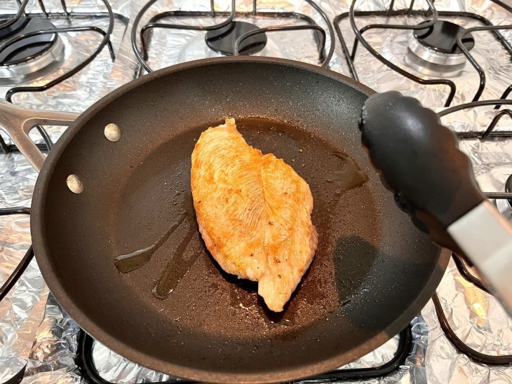 Filé de frango grelhado em uma frigideira.