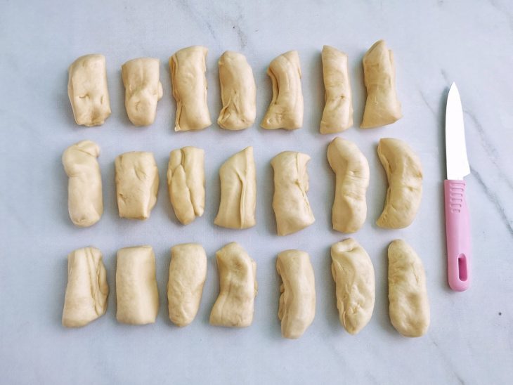 Massa dividida em pequenas porções com faca.