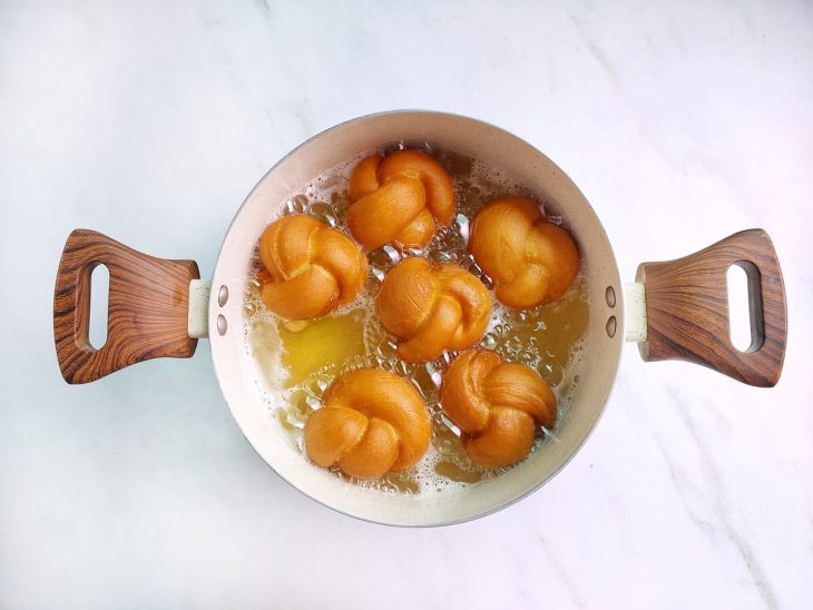 Nozinhos fritando em óleo quente em fogo médio.