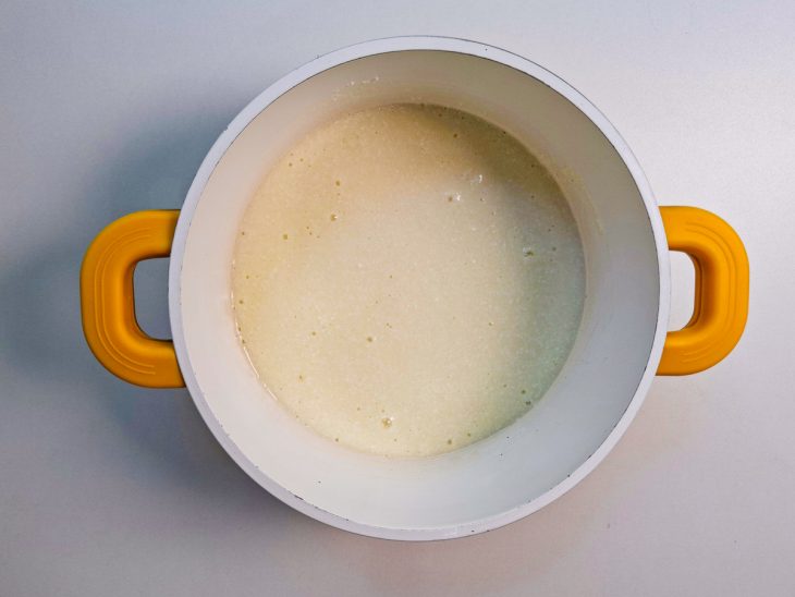 Leite condensando, coco e manteiga na panela.