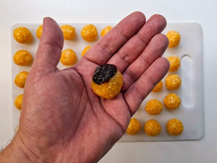Ameixas sendo encaixadas nas bolinhas de coco.