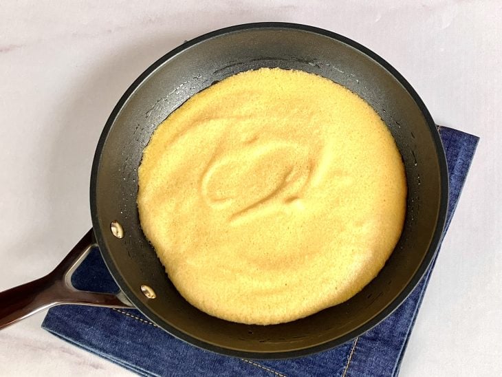 Uma frigideira contendo uma omelete sendo cozido.