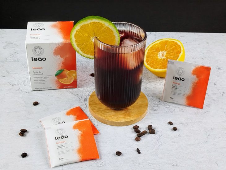 Orange coffee pronto para consumo servido em um copo de vidro decorado com uma rodela de laranja.