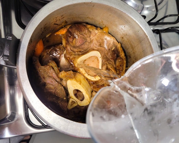 Uma penela de pressão com vegetais e carne.