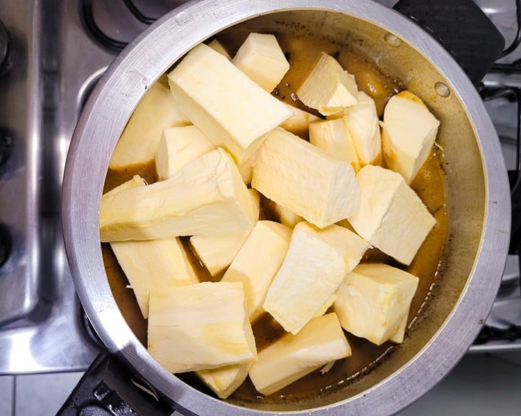 Uma penela de pressão com caldo e mandiocas.