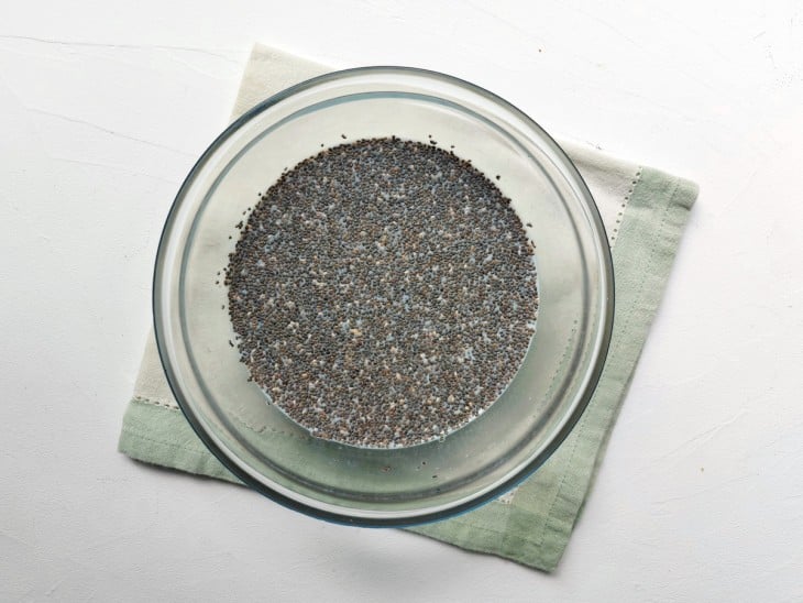 Um recipiente com a mistura de chia, aveia em flocos, mel e leite.