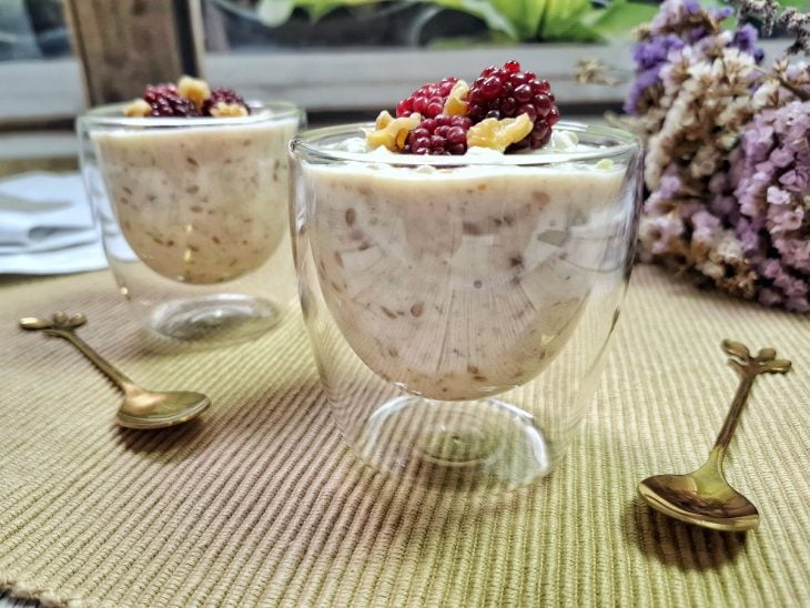 Overnight oats prontas para consumo em uma pequena taça de vidro.