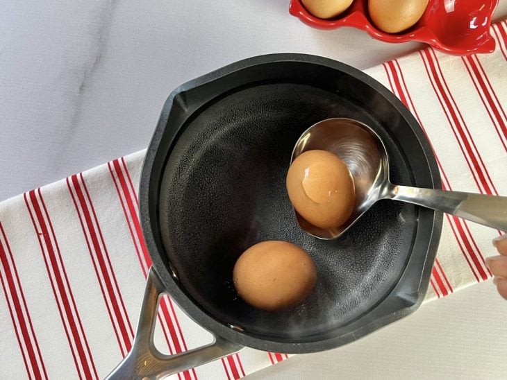 Uma panela com água quente e ovos.