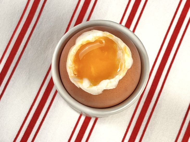 Um recipiente contendo ovo cozido com gema bem mole.