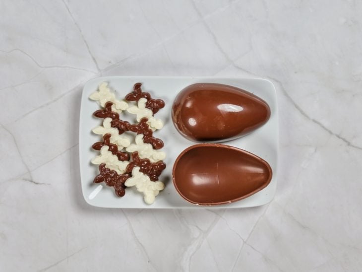 Um prato com ovo de Páscoa e coelhinhos de chocolate desenformados.