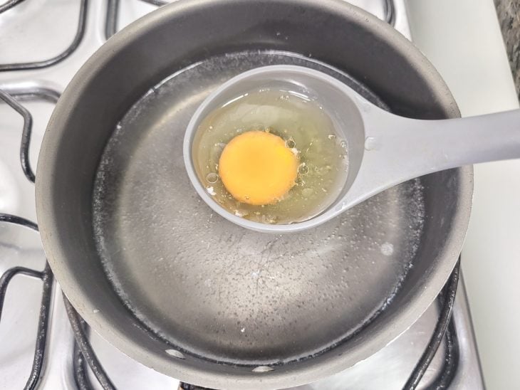 Uma panela contendo água fervendo com um ovo.