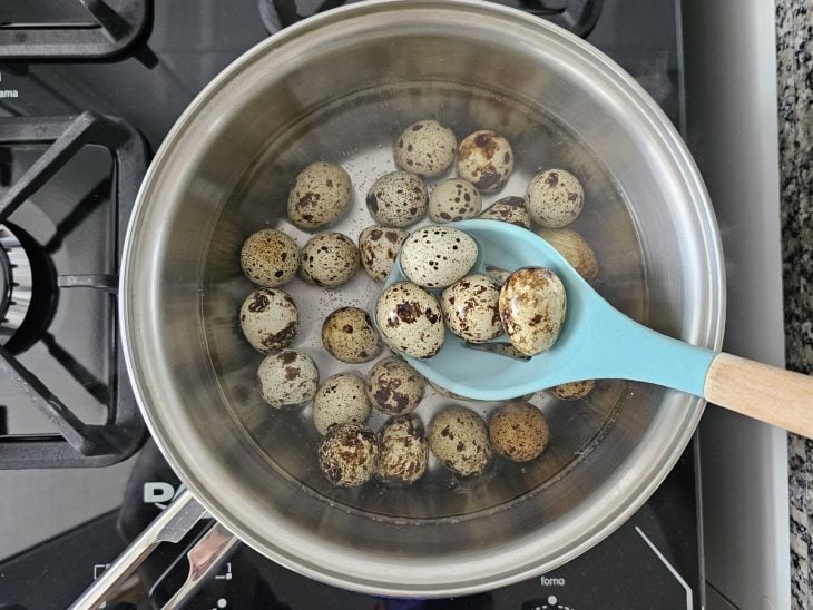 Uma panela contendo água e ovos de codorna.