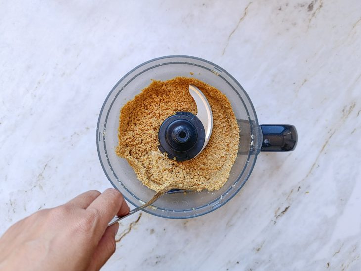 No processador, os ingredientes batidos em uma farofa.