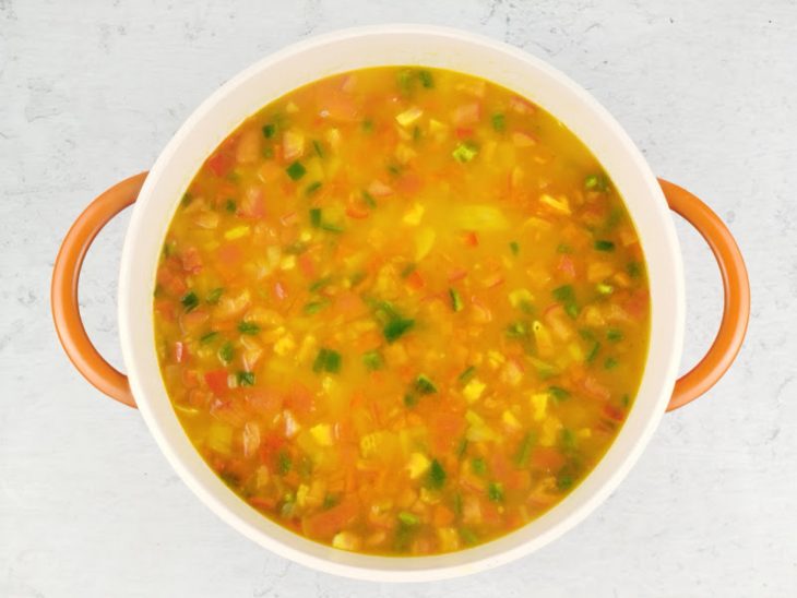 Caldo e açafrão adicionados na panela.