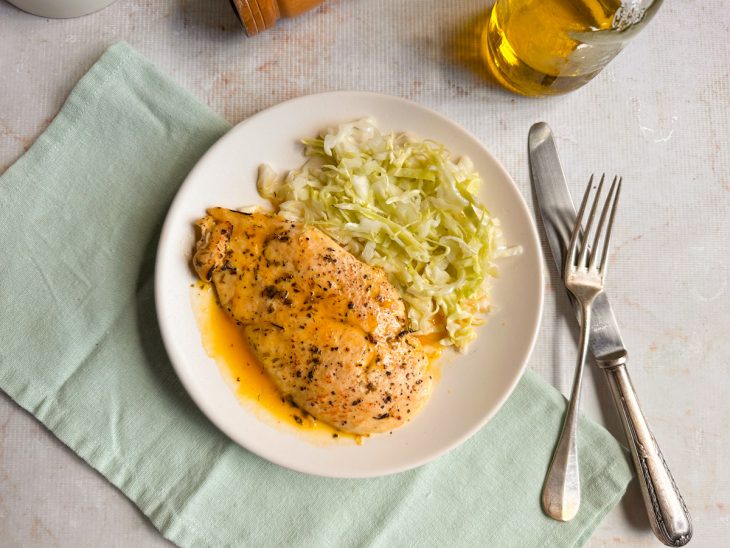 Paillard de frango servido com molho de laranja por cima.