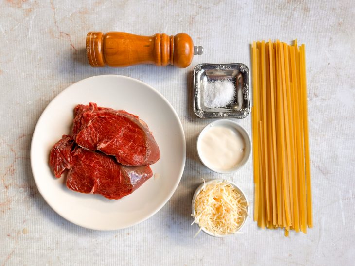Ingredientes organizados na bancada com queijo parmesão ralado fino.