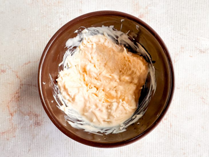 Creme de leite e parmesão misturados em uma tigela.