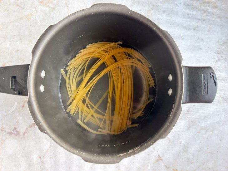 Fettuccine cozinhando em panela com água e sal.