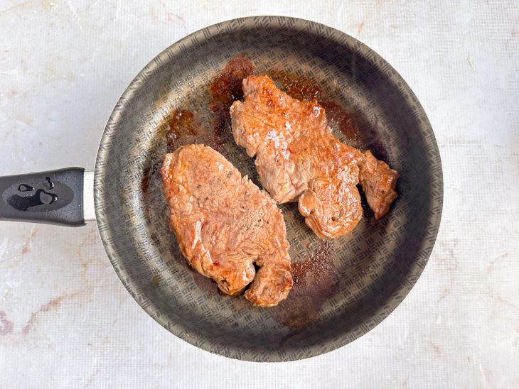Paillard de mignon grelhando na frigideira bem quente.
