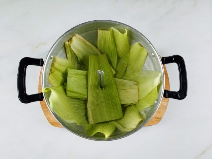 Cuscuzeira com água e folhas.