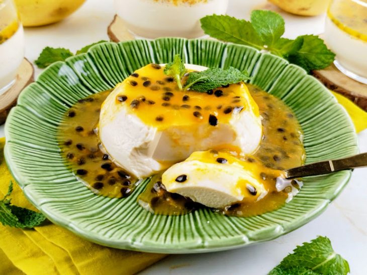 Panacota pronta, servida em prato, colher retirando uma porção.