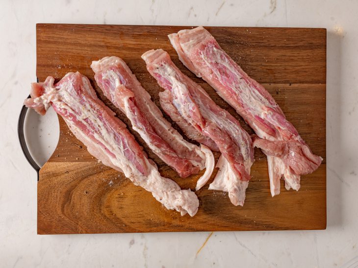 Uma tábua com as pancetas temperadas.