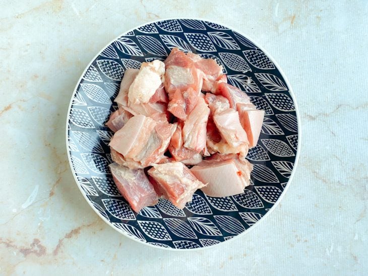 Pedaços de panceta temperados com sal no mesmo prato.