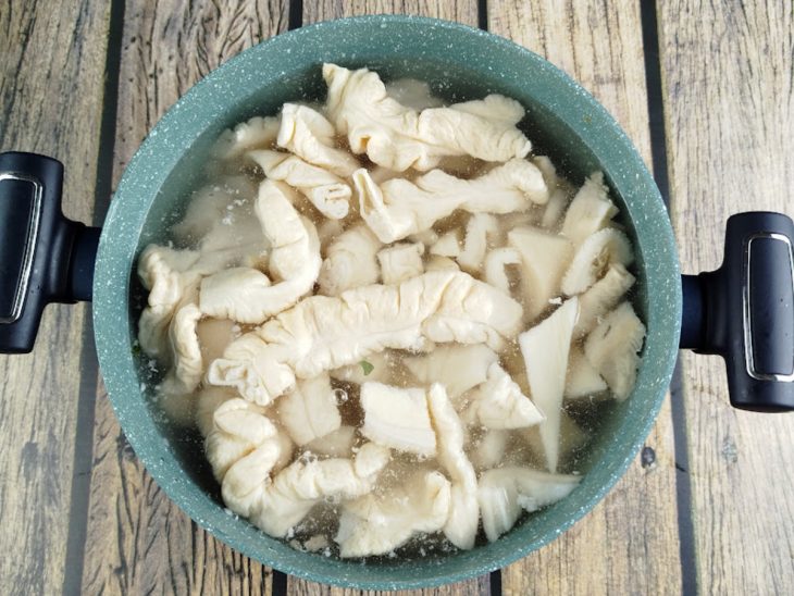 Pedaços de bucho e tripa colocados na panela com água.