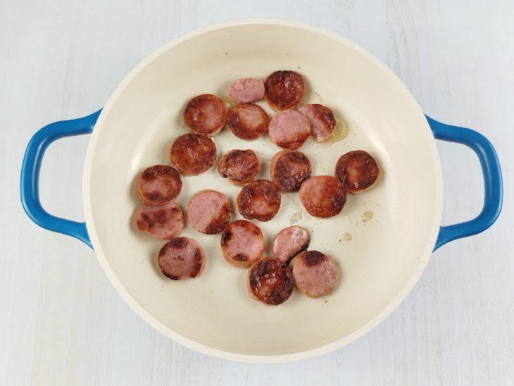 Numa frigideira, a linguiça calabresa frita.