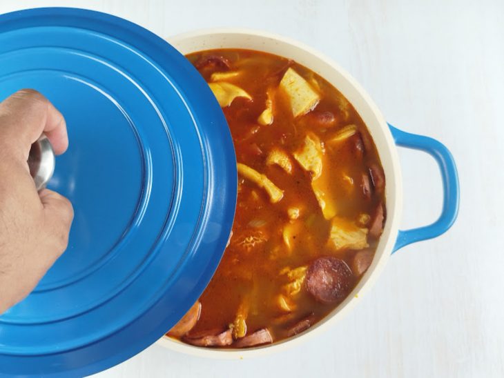 Na panela, as calabresas adicionadas, e a tampa sendo colocada.