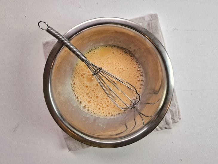 Recipiente com ovos batidos sobre um pano