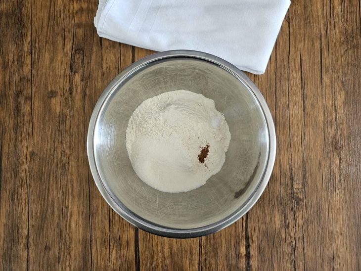 Um recipiente contendo a mistura de farinha, açúcar, canela e sal.