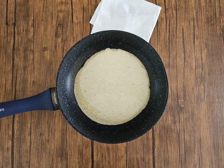 Uma frigideira cozinhando a massa de panqueca.