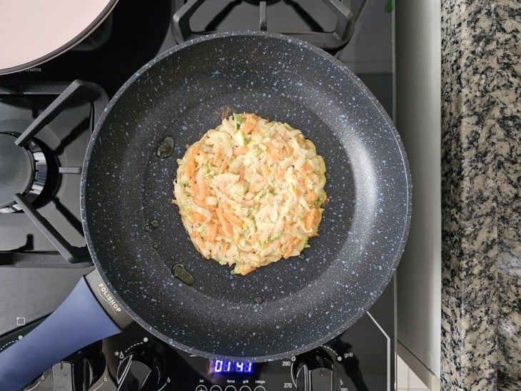 Porção da massa de legumes colocada na frigideira.