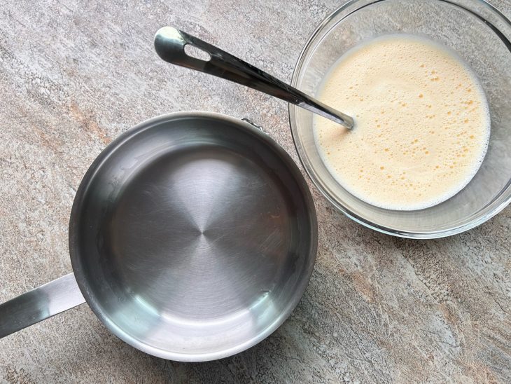 Panela untada com azeite ao lado de uma tigela com massa de panqueca.