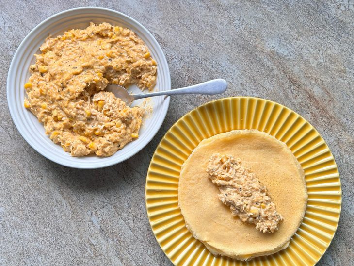Porção de recheio de frango sobre uma panqueca em um prato.