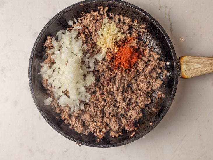 Temperos e ingredientes adicionados na frigideira com carne moída.