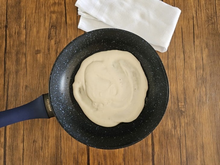 Frigideira com massa de panqueca vegana ainda crua.