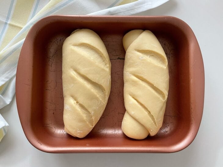 Pães descansando na assadeira para crescer novamente antes de assar.