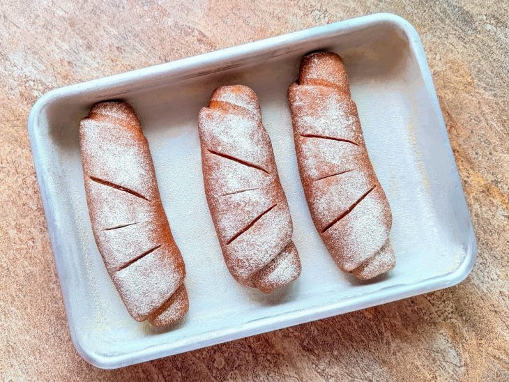 Pães após o tempo de crescimento e cortados.