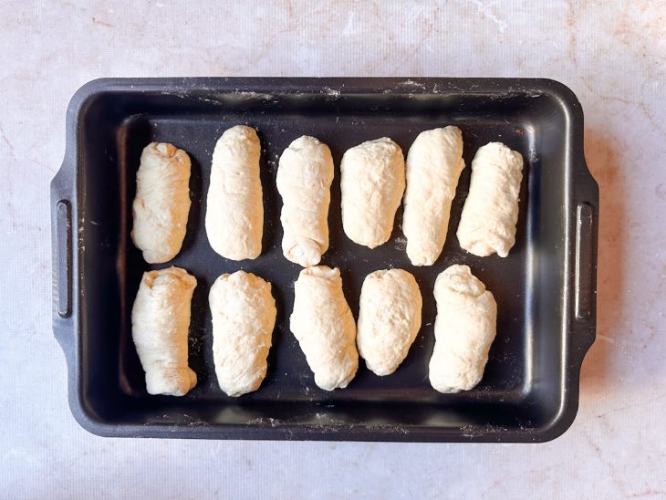 Pães modelados e acomodados na assadeira.